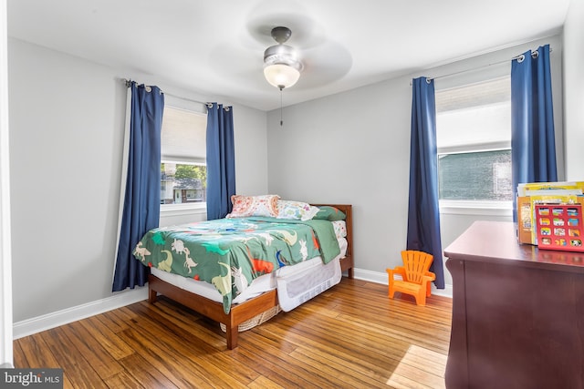 bedroom featuring wood finished floors, baseboards, and a ceiling fan