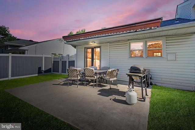 back of house at dusk featuring a patio and outdoor dining area