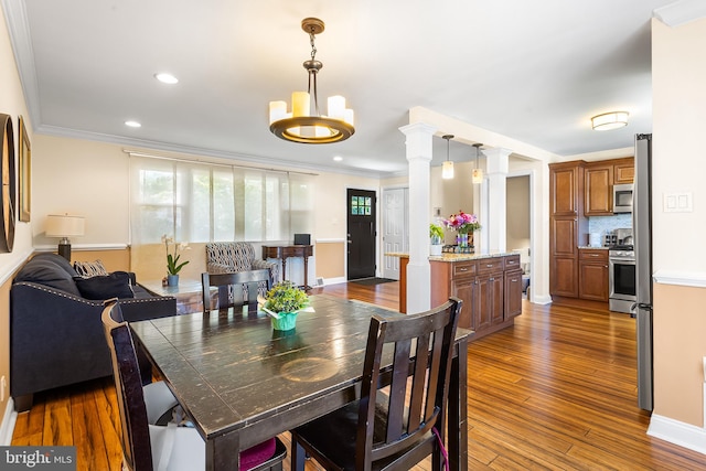 dining area featuring dark wood-style flooring, a chandelier, ornamental molding, recessed lighting, and baseboards
