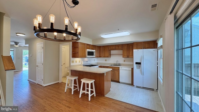 208 Eastern Ave, Annapolis, MD 21403 - kitchen featuring white appliances, open shelves, light wood-style floors, a kitchen bar, and light countertops