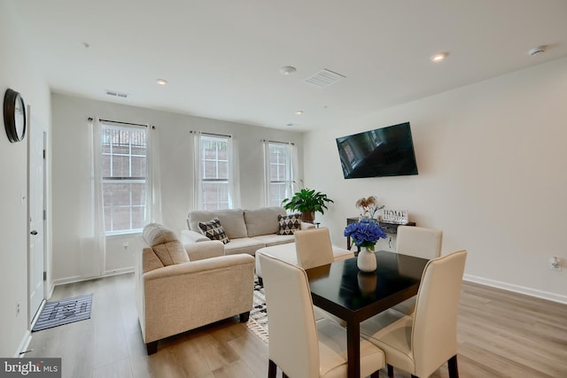 living room with light wood-type flooring, baseboards, and recessed lighting