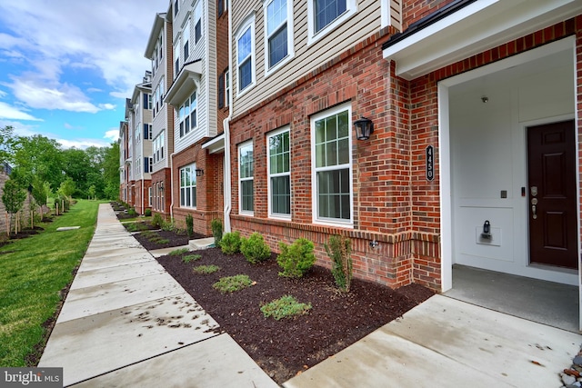 doorway to property with brick siding and a residential view