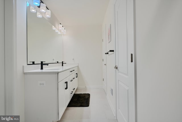 bathroom featuring double vanity, tile patterned flooring, and baseboards
