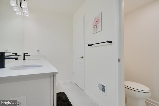bathroom with toilet, double vanity, baseboards, and tile patterned flooring