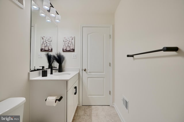 half bath featuring vanity, toilet, and baseboards