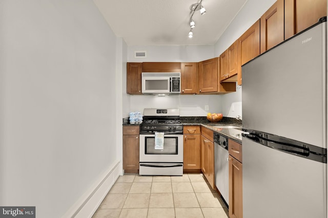 1245 4th St SW Unit E511, Washington, DC 20024 - kitchen featuring stainless steel appliances, light tile patterned floors, brown cabinets, and dark stone counters