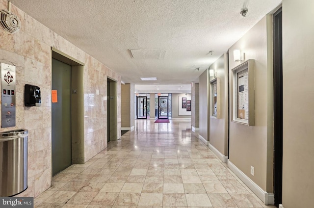 3100 S Manchester St Unit 224, Falls Church, VA 22044 - hall with elevator, a textured ceiling, light marble finish floors, and baseboards