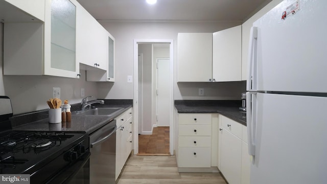 3100 S Manchester St Unit 224, Falls Church, VA 22044 - kitchen featuring freestanding refrigerator, black gas range oven, stainless steel dishwasher, a sink, and light wood finished floors