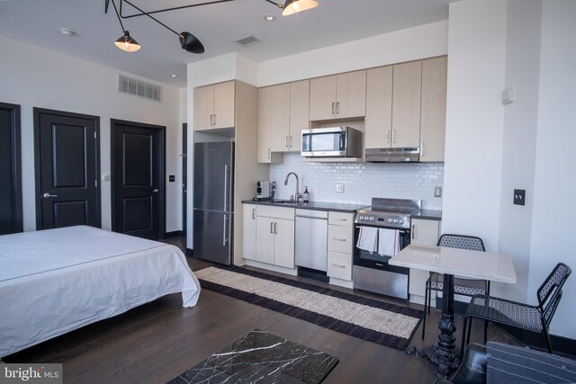 2550 17th St NW Unit 604, Washington, DC 20009 - kitchen with stainless steel appliances, dark wood-style flooring, under cabinet range hood, dark countertops, and tasteful backsplash