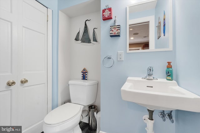 half bathroom with toilet and baseboards