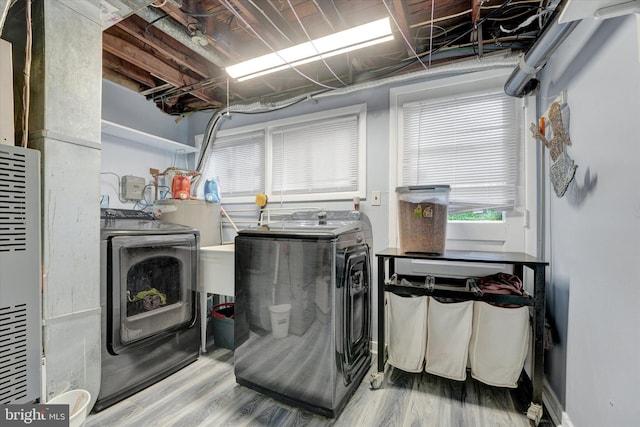 washroom with washing machine and dryer and wood finished floors