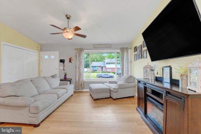 living room featuring a ceiling fan and light wood-style flooring