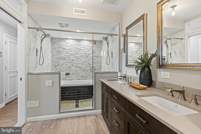 full bathroom featuring a shower stall, wood finished floors, and double vanity