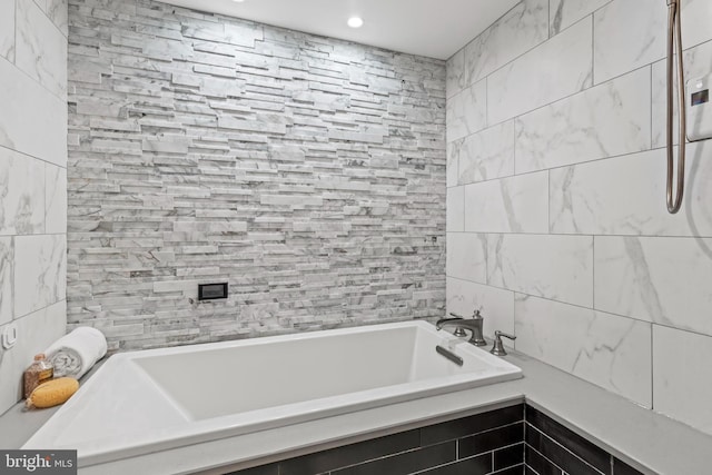 bathroom with a tub, tile walls, and recessed lighting