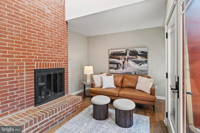 living room with wood finished floors, baseboards, and a fireplace