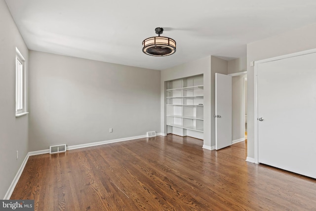 unfurnished bedroom featuring wood finished floors and baseboards