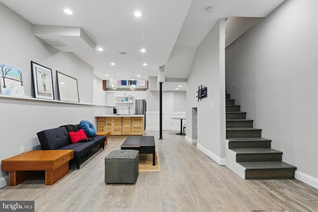 living area with light wood finished floors, baseboards, stairway, and recessed lighting