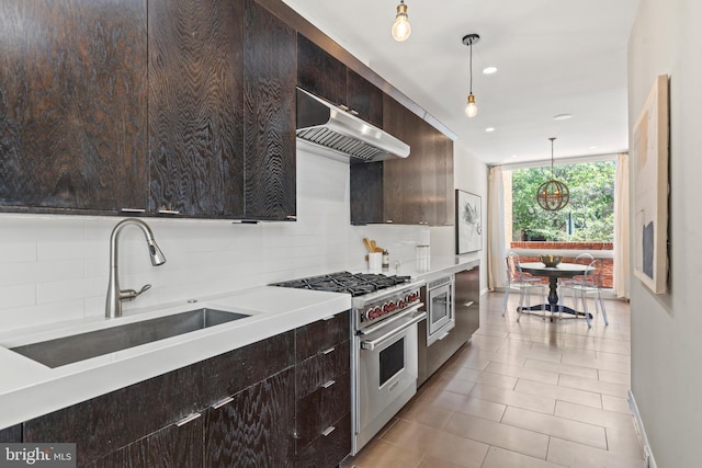 kitchen with appliances with stainless steel finishes, under cabinet range hood, backsplash, a sink, and dark brown cabinetry