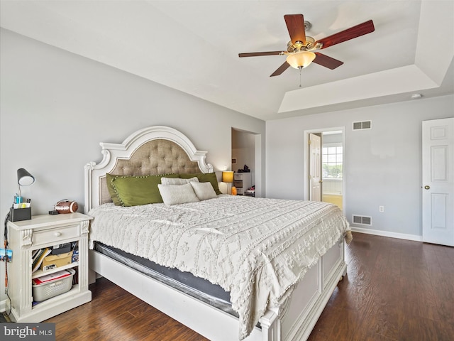 67 Tinning Ct, Hedgesville, WV 25427 - bedroom with dark wood-type flooring, baseboards, a tray ceiling, connected bathroom, and a ceiling fan