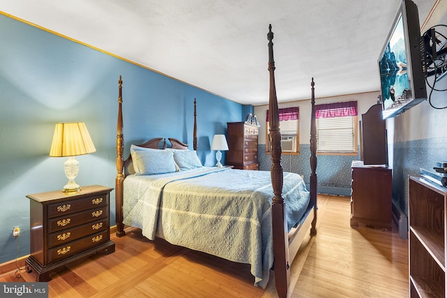 bedroom featuring wood finished floors and cooling unit