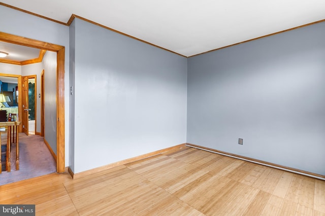 spare room with ornamental molding and baseboards