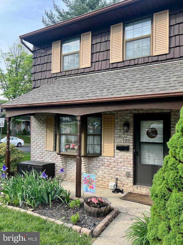 view of front of home with roof with shingles and covered porch