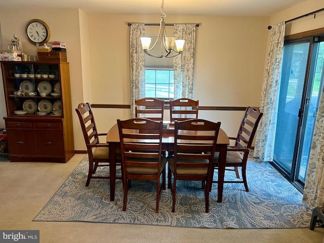 dining area with a chandelier and carpet floors