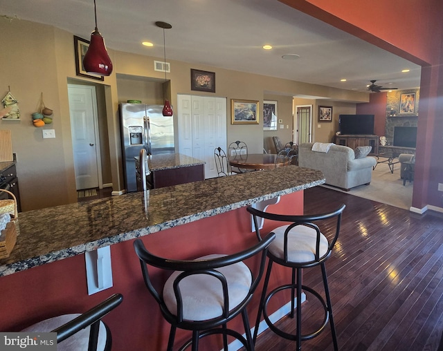 85 Malek Dr, Hanover, PA 17331 - kitchen with stainless steel refrigerator with ice dispenser, wood-type flooring, ceiling fan, a kitchen bar, and a fireplace
