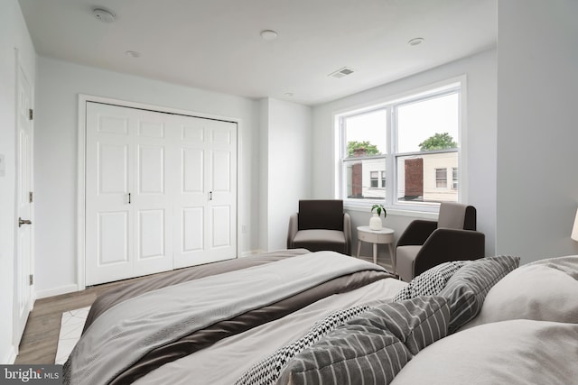 bedroom featuring wood finished floors, a closet, and baseboards