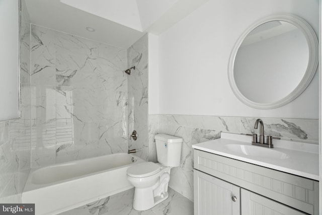 full bathroom featuring tile walls, marble look tile flooring, vanity, shower / washtub combination, and a wainscoted wall
