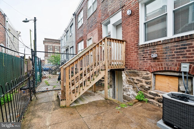 view of patio / terrace featuring central AC unit, a gate, stairway, and a deck