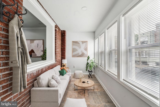 sunroom / solarium with baseboards and stone finish flooring