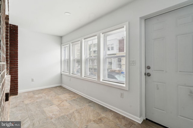 foyer entrance featuring baseboards