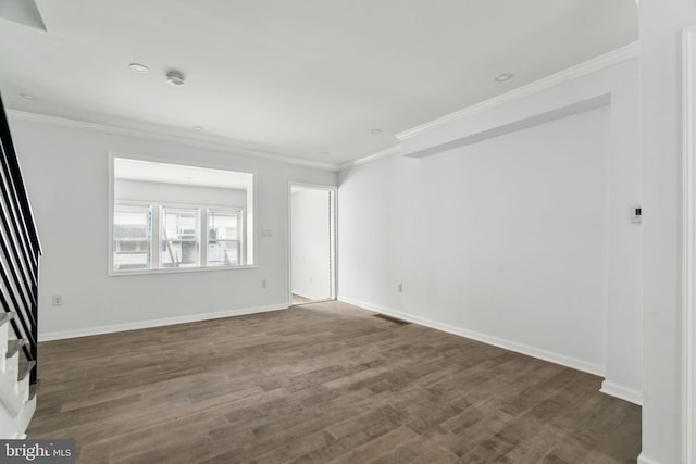 empty room featuring ornamental molding, dark wood finished floors, baseboards, and a smoke detector