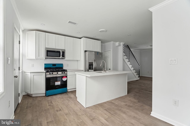 kitchen featuring stainless steel appliances, baseboards, a sink, and light wood-type flooring