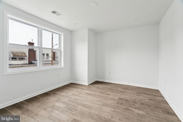 empty room featuring wood finished floors and baseboards