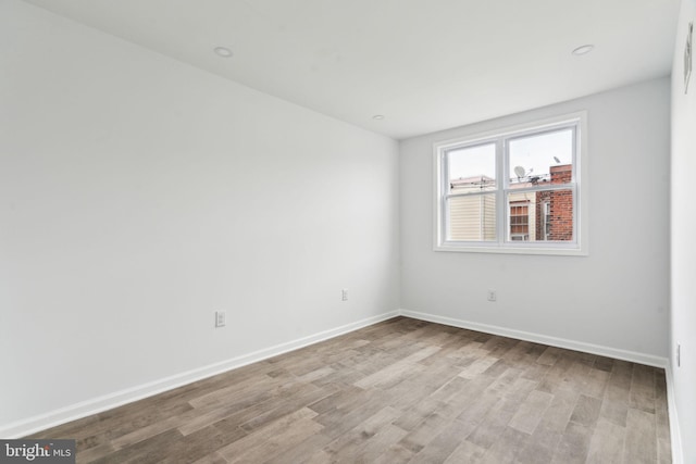 spare room featuring wood finished floors and baseboards