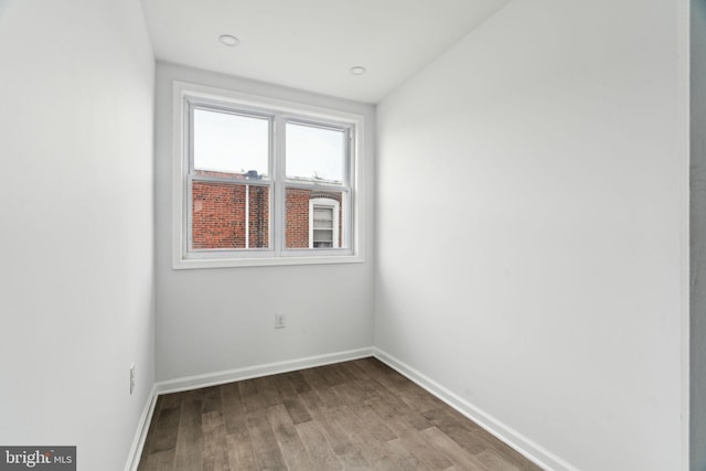 empty room featuring wood finished floors and baseboards