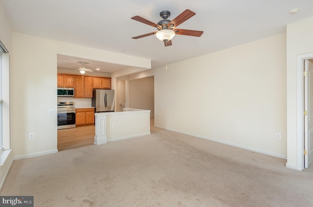 unfurnished living room featuring light colored carpet, ceiling fan, and baseboards