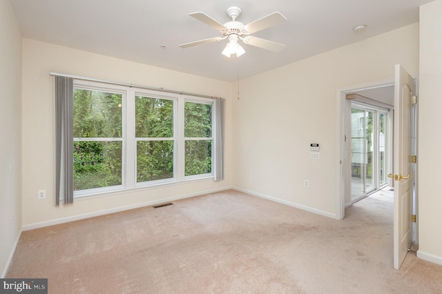 unfurnished room with light carpet, baseboards, healthy amount of natural light, and a ceiling fan