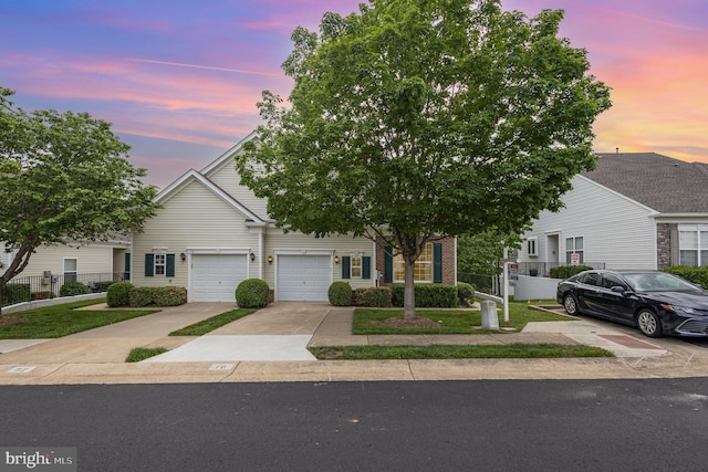 view of front of house with fence, concrete driveway, a garage, and brick siding