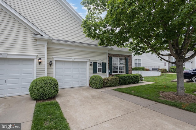 multi unit property with driveway, a front yard, and brick siding