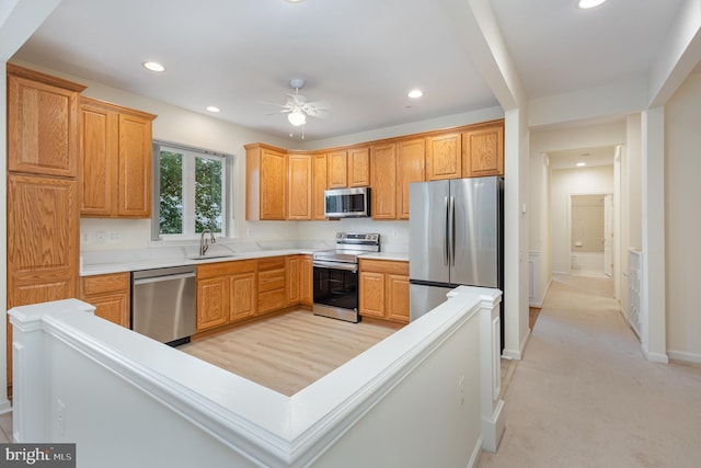 kitchen with appliances with stainless steel finishes, a sink, recessed lighting, ceiling fan, and light countertops