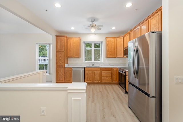 kitchen featuring stainless steel appliances, a sink, light wood finished floors, ceiling fan, and recessed lighting