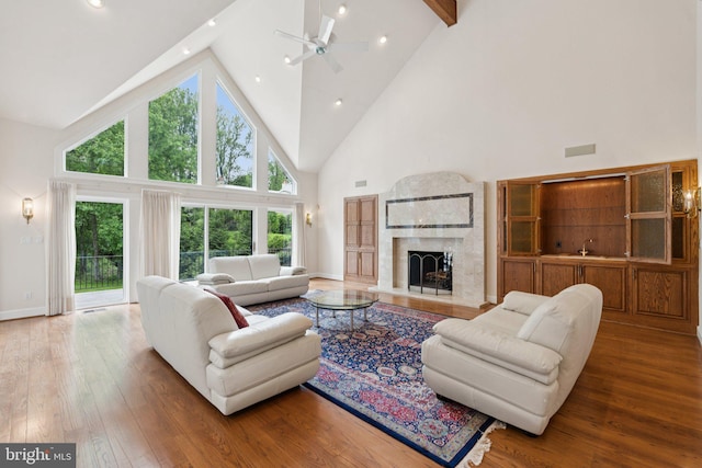6723 Georgetown Pike, Mclean, VA 22101 - living area with high vaulted ceiling, hardwood / wood-style floors, ceiling fan, a fireplace with raised hearth, and beam ceiling