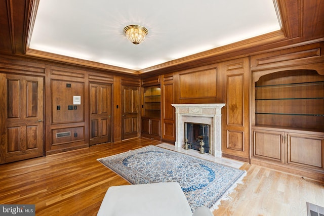 6723 Georgetown Pike, Mclean, VA 22101 - living area featuring ornamental molding, built in features, wooden walls, a high end fireplace, and light wood finished floors