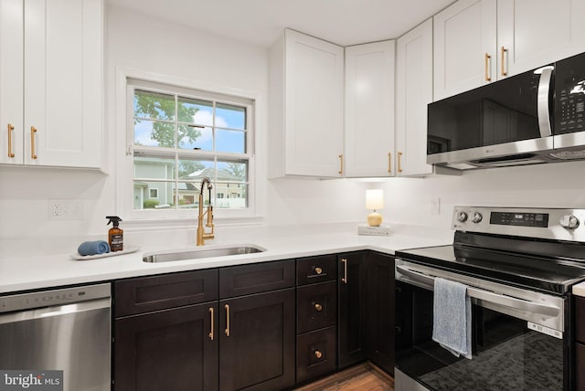 5632 Maxine Ct, Alexandria, VA 22310 - kitchen with appliances with stainless steel finishes, a sink, white cabinets, light countertops, and wood finished floors
