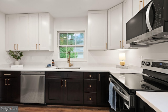 5632 Maxine Ct, Alexandria, VA 22310 - kitchen featuring stainless steel appliances, a sink, white cabinetry, light countertops, and dark wood-style floors