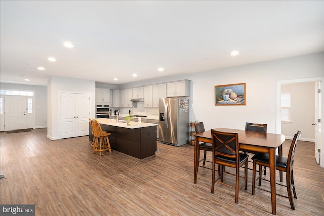 dining space with recessed lighting, baseboards, and wood finished floors