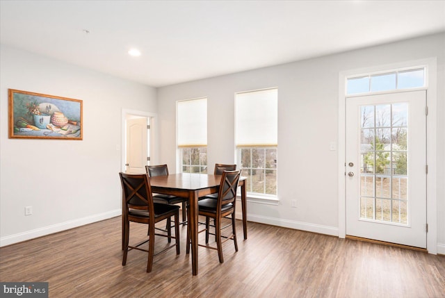 dining room with baseboards, wood finished floors, plenty of natural light, and recessed lighting